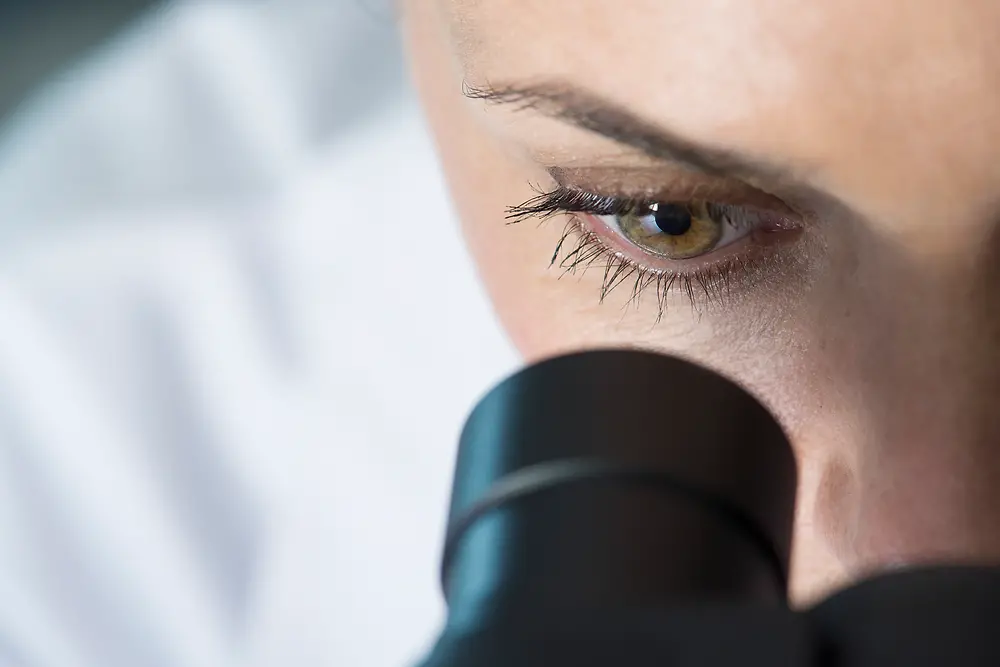 현미경을 들여다보는 여성의 눈
