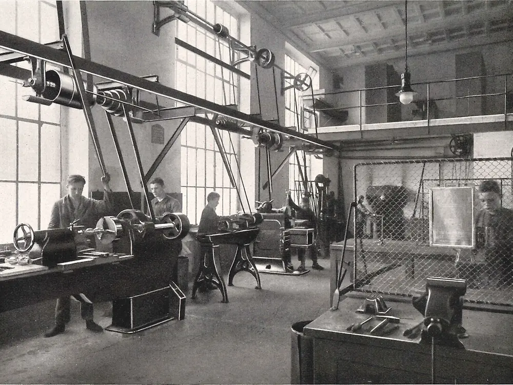 금속 가공 작업장에서 기계를 다루고 있는 견습생들.