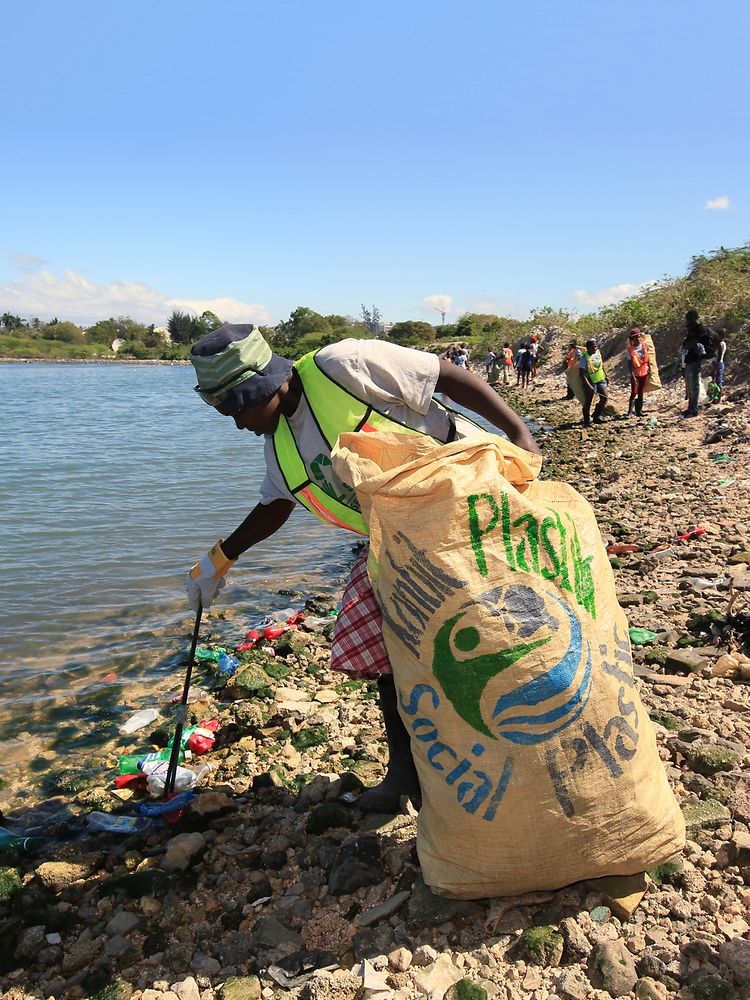 해변에서 플라스틱 쓰레기를 모으는 여성들